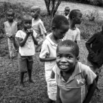 Black and white photography of children in a Kenyan village, capturing their natural expressions and the spirit of community.
